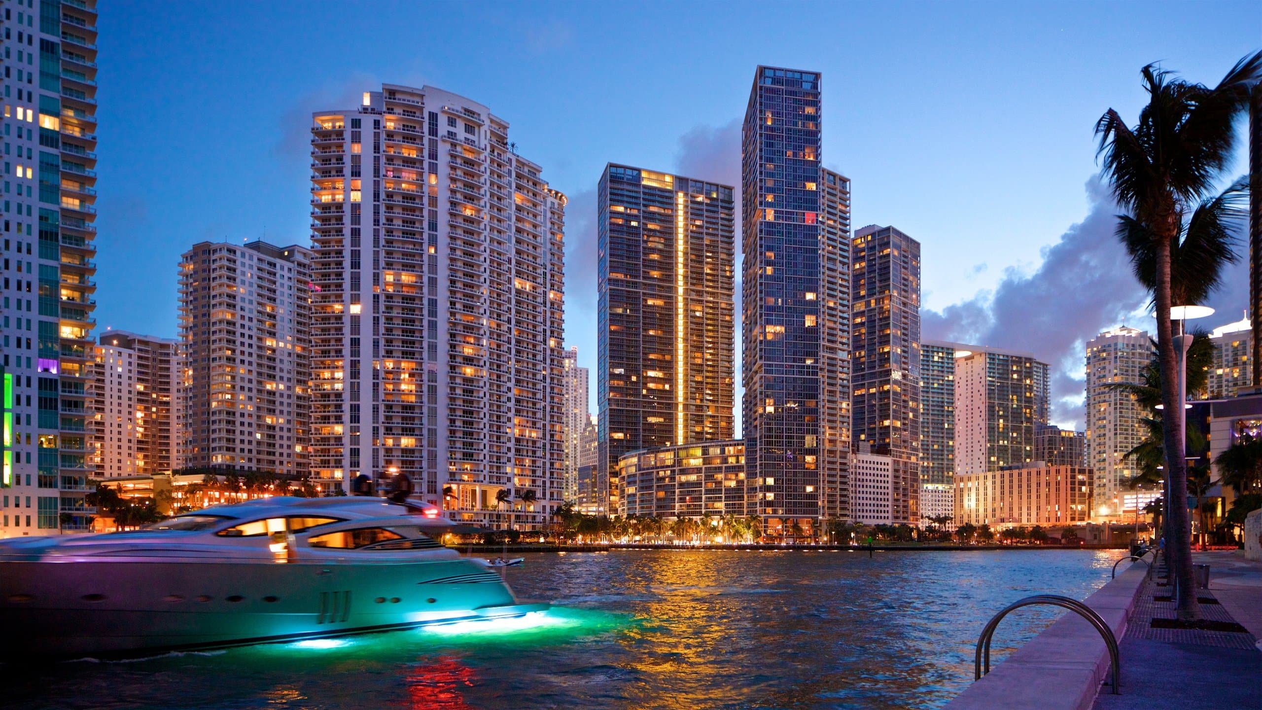 The downtown Miami and Brickell skyline at dusk, its towers reflected across Biscayne Bay.